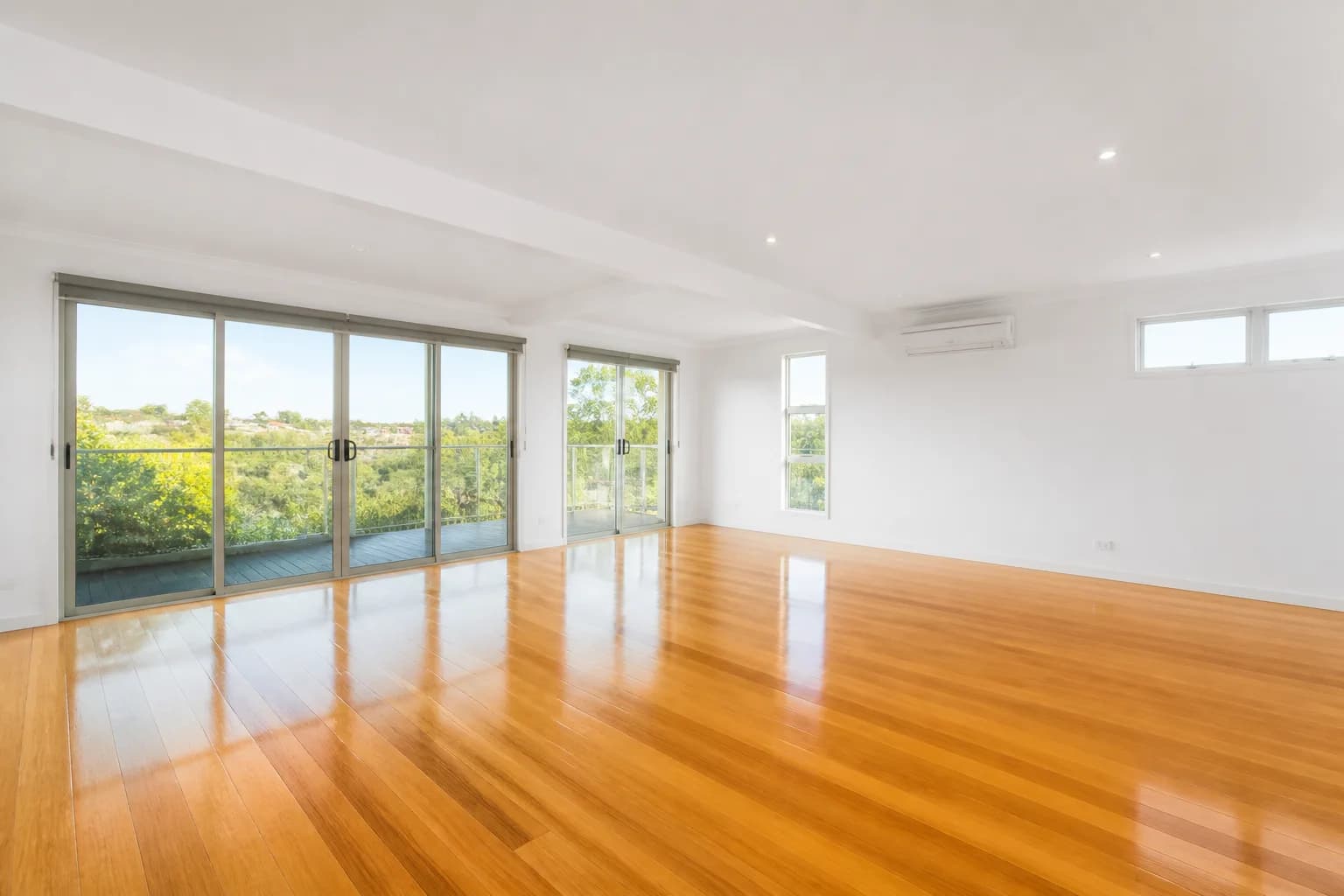 Empty bright living room with gleaming floors ready for new tenants